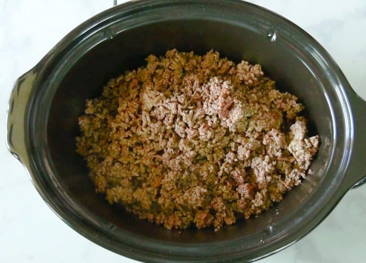 Browned ground beef is added to the slow cooker