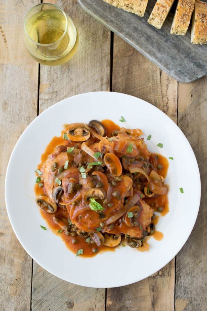 A plate of chicken cacciatore viewed from overhead