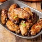 Orange chicken wings garnished with sesame seeds