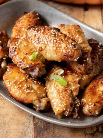 Orange chicken wings garnished with sesame seeds