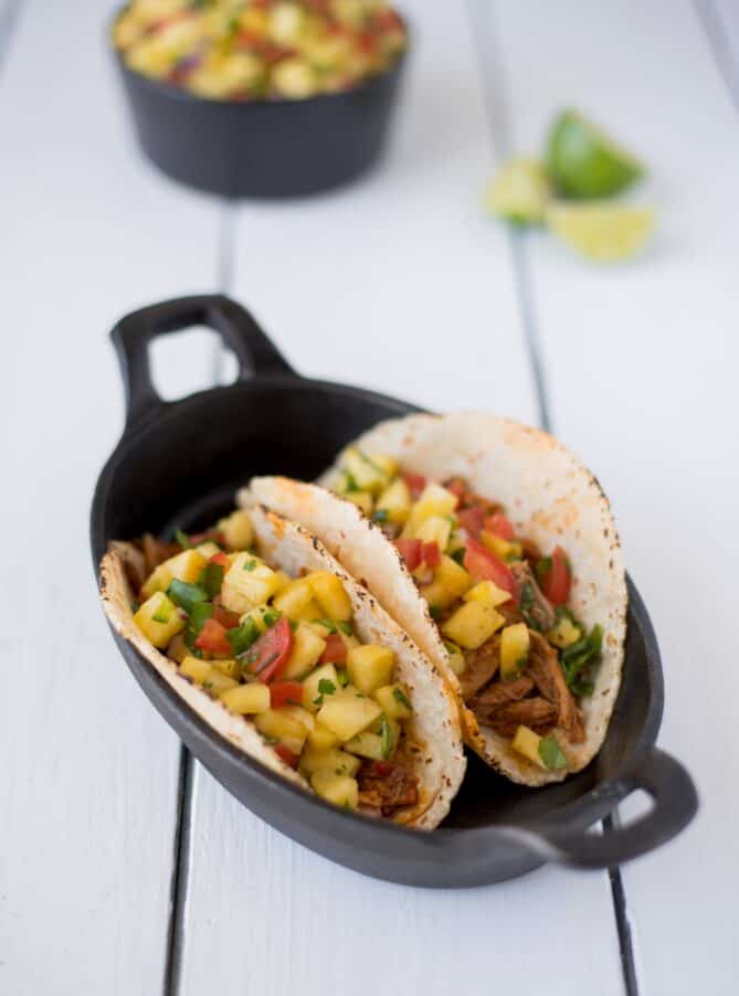 2 flour tortillas filled with shredded pork and pineapple salsa