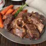 A platter of slow cooked short ribs with carrots
