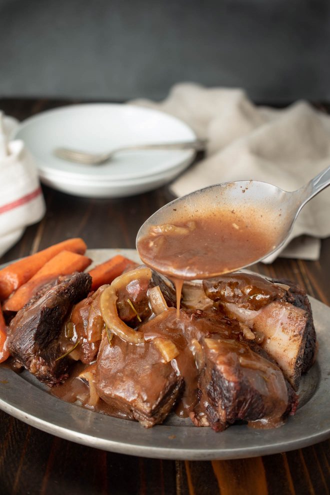 Pouring gravy over beef short ribs