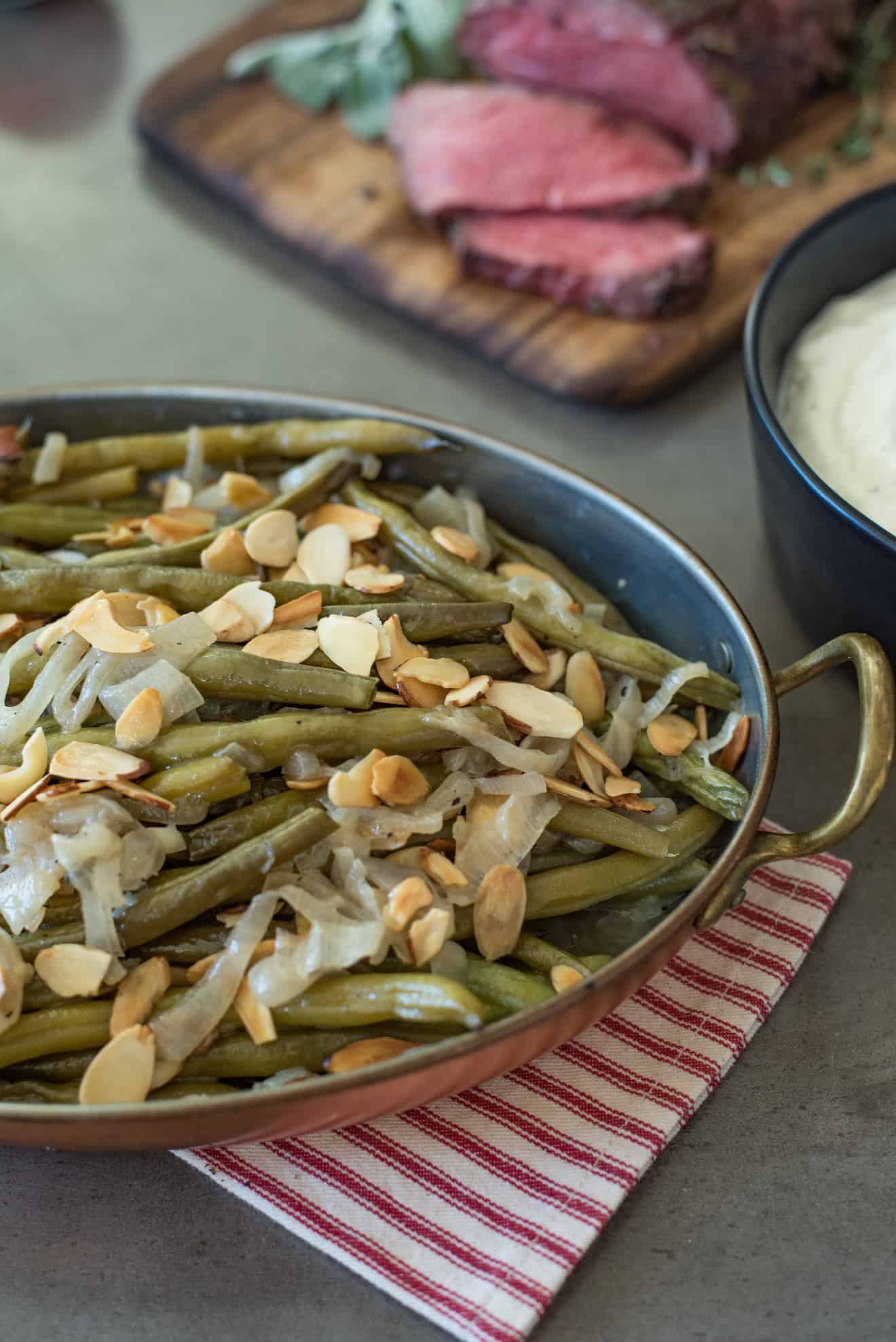 A closeup showing the shallots and toasted almonds on top of the green beans.