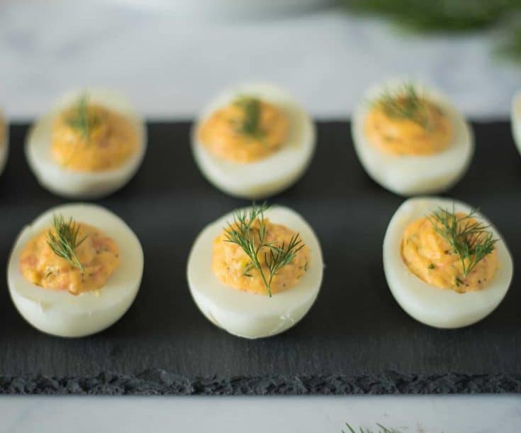 6 smoked salmon deviled eggs on a serving plate garnished with fresh dill