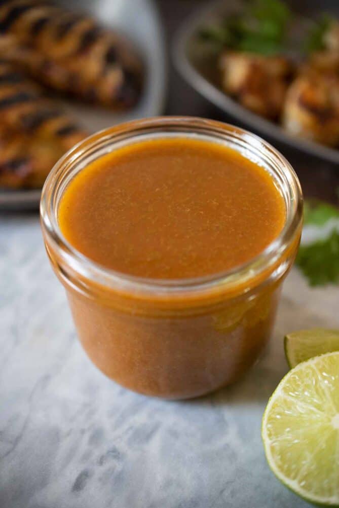 A jar of dark orange spicy jalapeño lime sauce