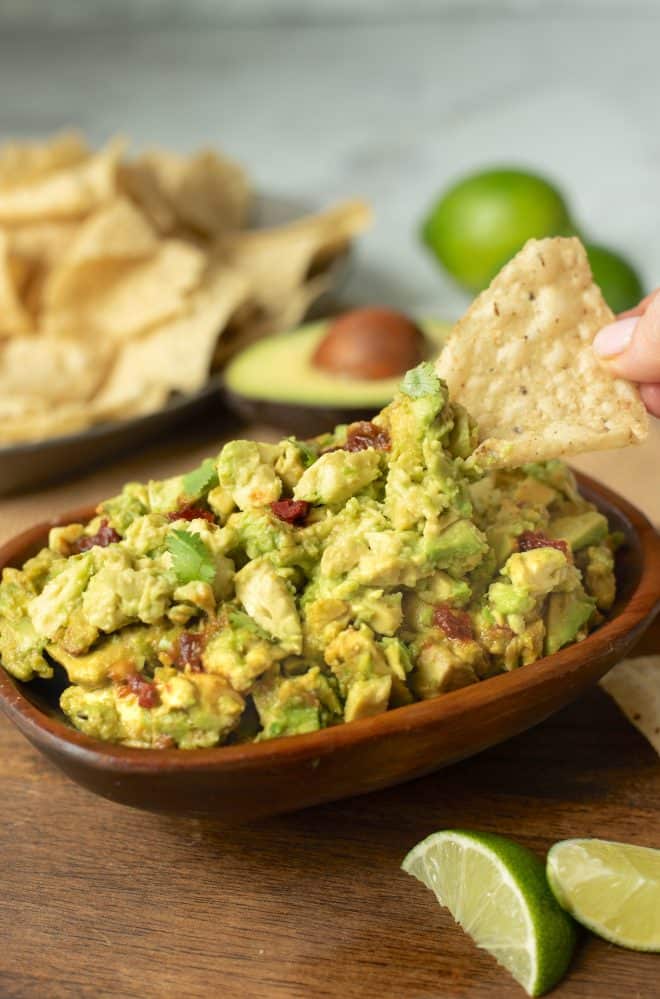 Scooping up guacamole with a tortilla chip