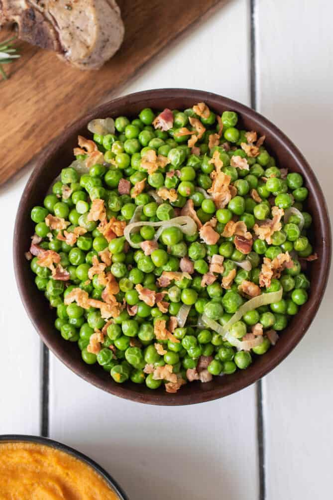 Spring peas and pancetta in a bowl viewed from overhead