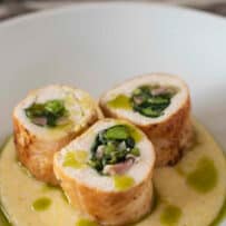 3 slices of chicken roulade sitting on top of polenta