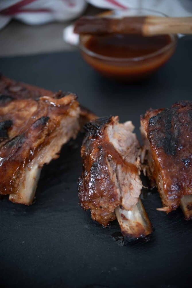 Cut baby back ribs with a bowl of Guinness sauce