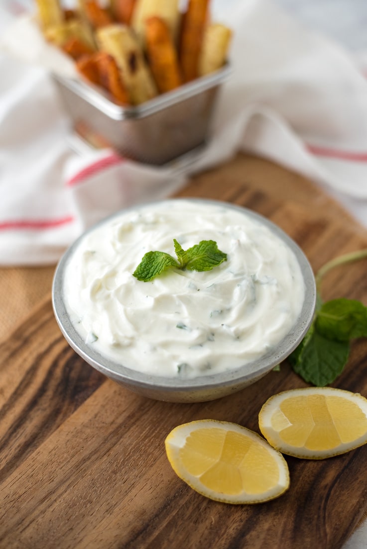 Mint yogurt dip garnished with fresh mint and lemon wedges