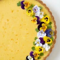 Pretty edible flowers garnish one side of the pie