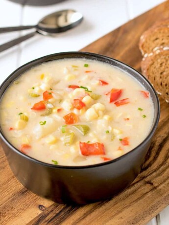 A creamy bowl of corn chowder served with sliced bread