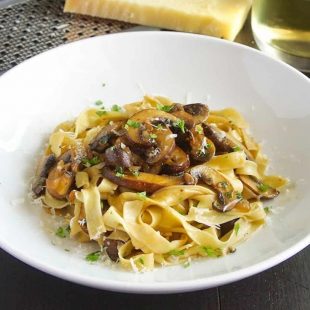 Fresh tagliatelle topped with mushrooms cooked in wine