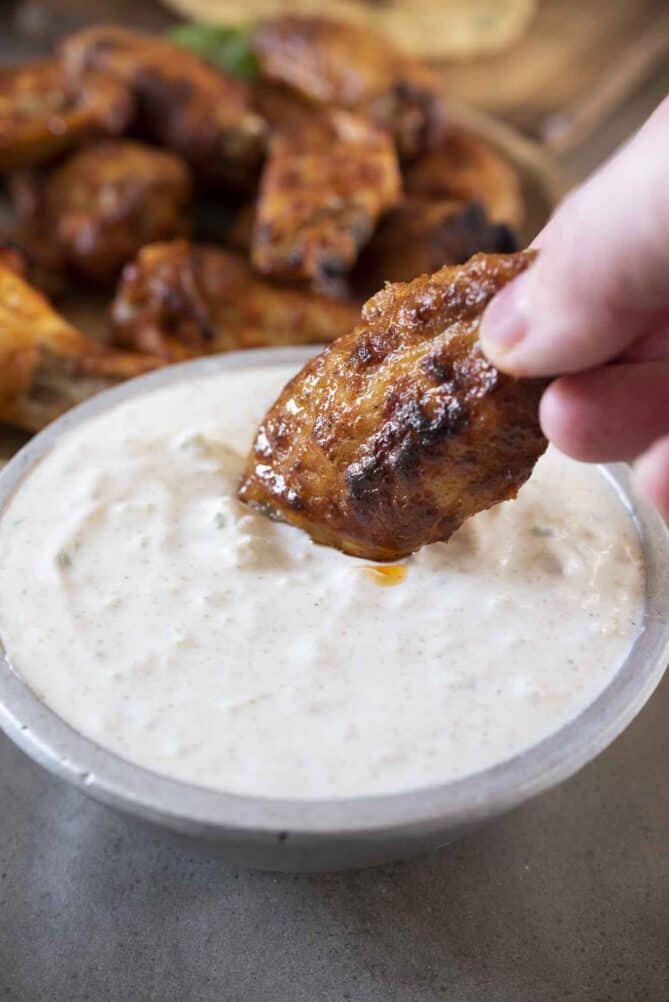 Dipping an Indian chicken wing into raita