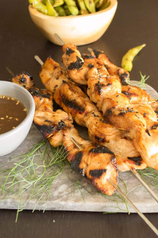 Perfect grill marks all over the chicken kabobs served with a side of edamame