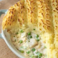 A closeup of the filling of British fish pie showing the green peas