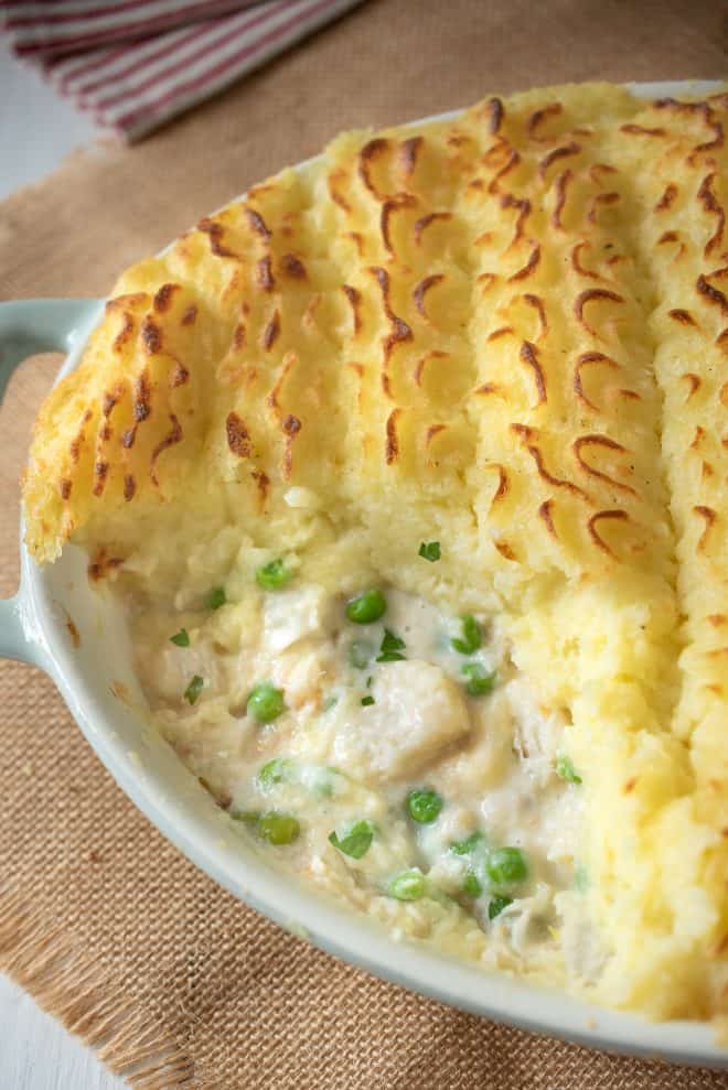 A closeup of the filling of British fish pie showing the green peas