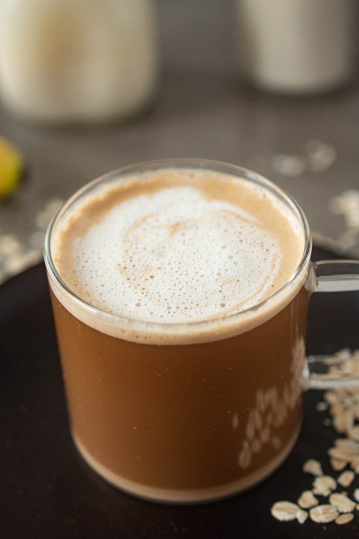 A latte made with oat milk in a glass mug