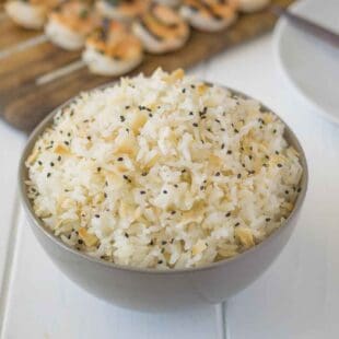 Coconut rice in a bowl with toasted coconut flakes