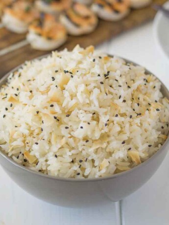 Coconut rice in a bowl with toasted coconut flakes