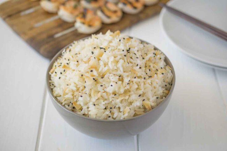 Coconut rice in a bowl with toasted coconut flakes