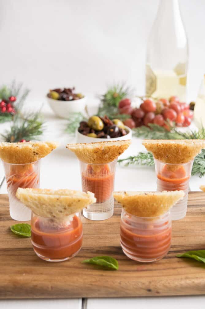 Tomato soup shots with mini grilled cheese on a board