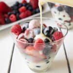 Frozen berries in a glass bowl with vanilla custard