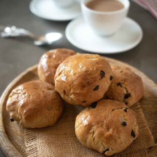 Currant studded teacake buns served with a cup of tea