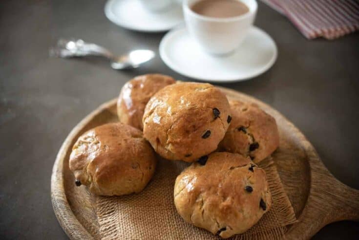 Currant studded teacake buns served with a cup of tea