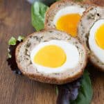 A closeup of the inside of a Scotch egg showing the bright yolk