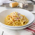 Spagetti topped with pancetta and Parmesan cheese