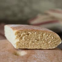 A triangle piece of bread on top of a round loaf
