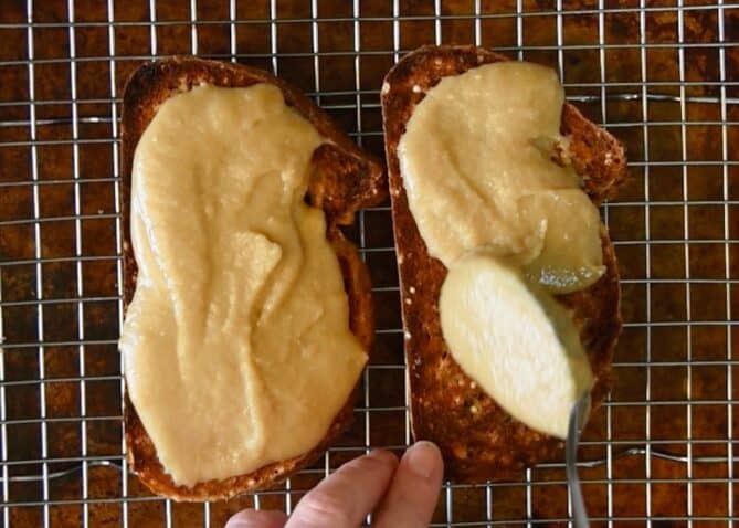 Spreading cheese sauce into toasted bread slices