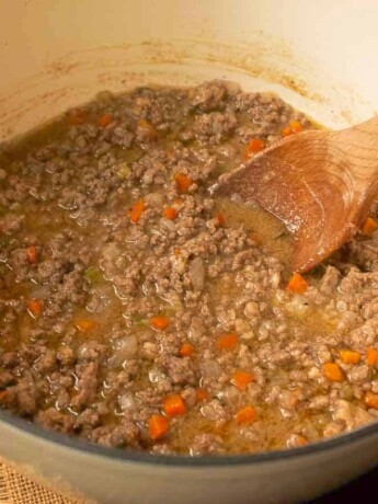 Meaty white Bolognese sauce in a white Dutch oven