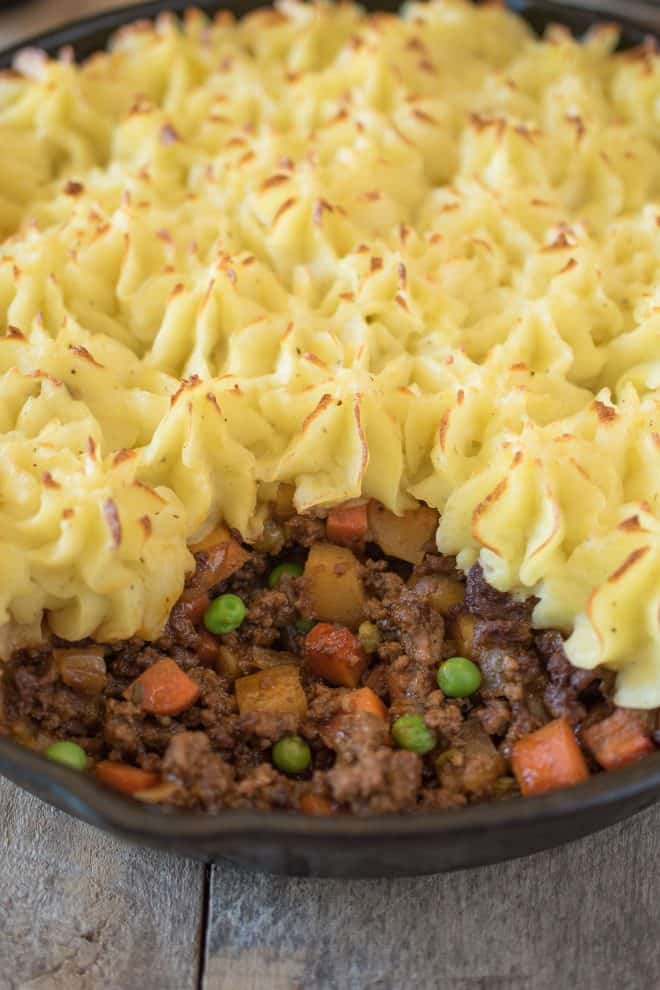 A closeup of the ground beef filling with carrots and peas
