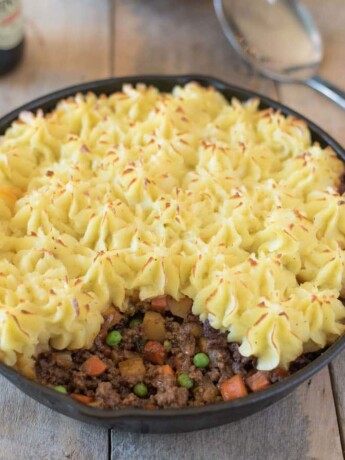 Fluffy and piped mashed potato on top of ground beef and vegetables