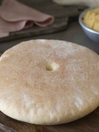 A round loaf of bread called stottie on a board.