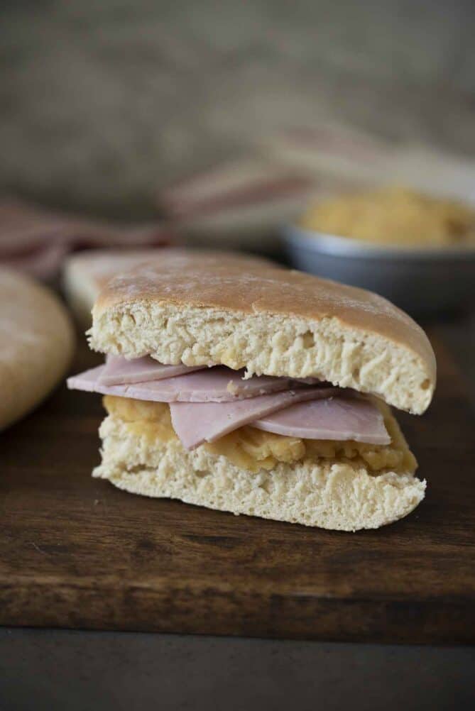 A sandwich made with ham and pease pudding viewed from the side