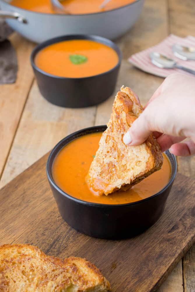 Dipping a grilled cheese sandwich into tomato soup