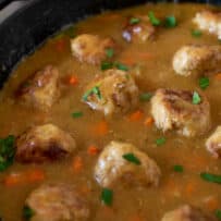 A closeup of turkey meatballs cooking in gravy