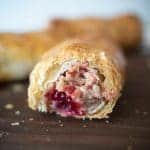 A view of the inside of the sausage rolls showing the bright cranberry and the flaky layers of pastry