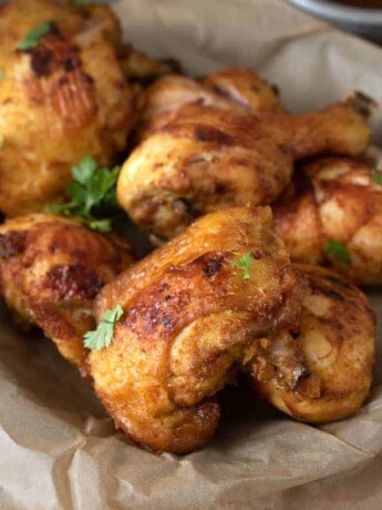 Turmeric Spiced Fried Chicken with Spicy Chili Sauce in a paper lined bowl