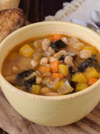 A colorful bean soup in a yellow bowl