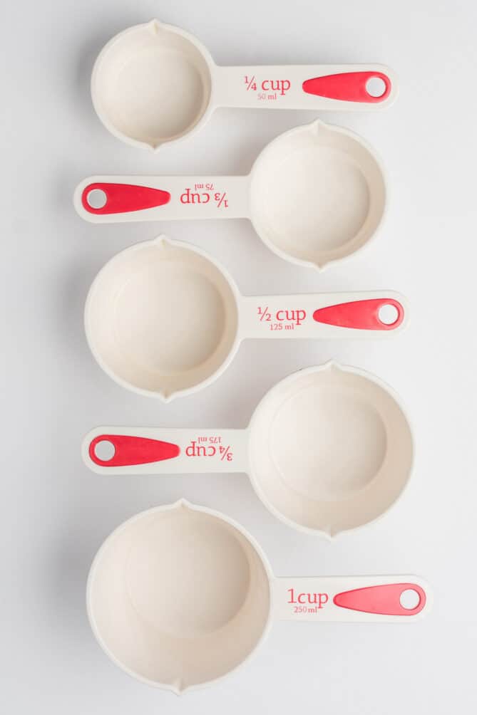 Set of Measuring Cups Staggered on White Background Top View