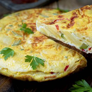 Serving a slice of potato and vegetable Spanish omelette