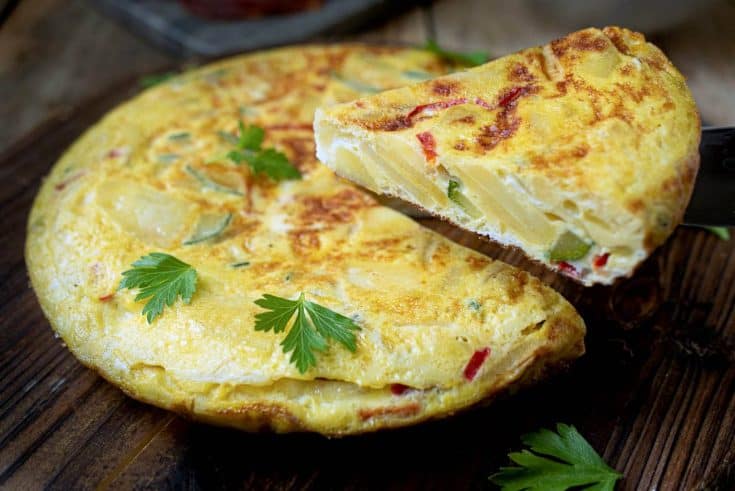 Serving a slice of potato and vegetable Spanish omelette