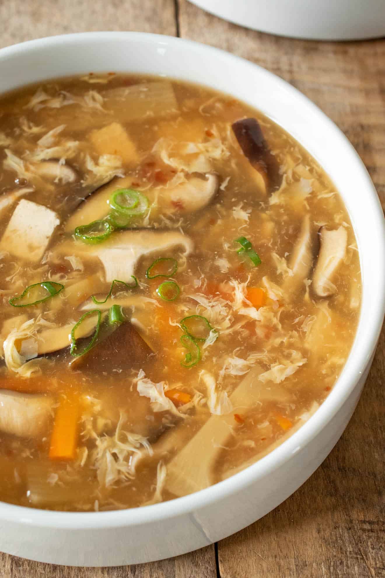 A closeup of the soup showing the mushrooms, tofu and vegetables