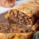 A sliced mushroom wellington showing the filling with mushroom and carrots