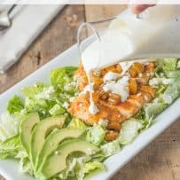 Drizzling dressing over chicken salad